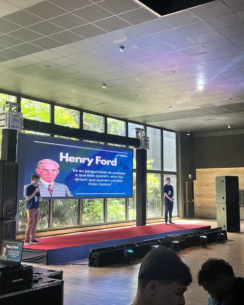 Palestra em auditório, com telão de LED no palco e o palestrante ao lado