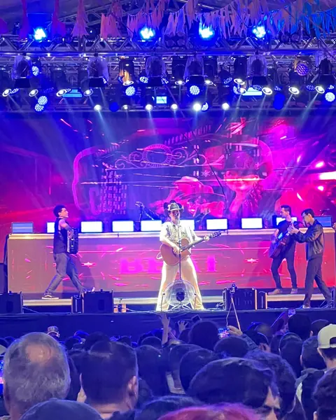 Show com painel de LED e luzes de palco, com o público à frente