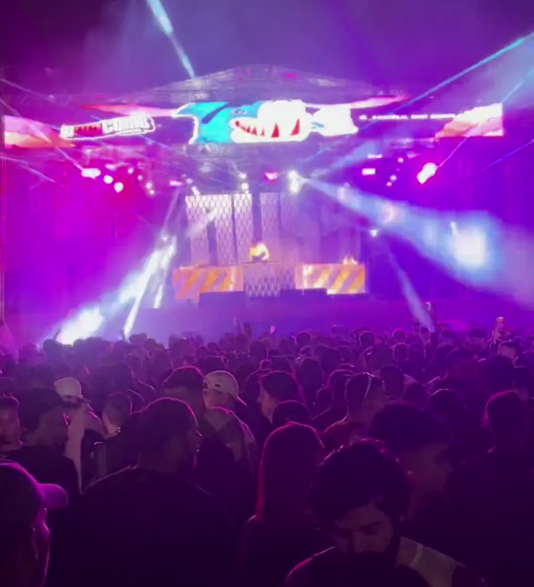 Palco com treliça e painel de LED, feixes de laser abrindo sobre o público